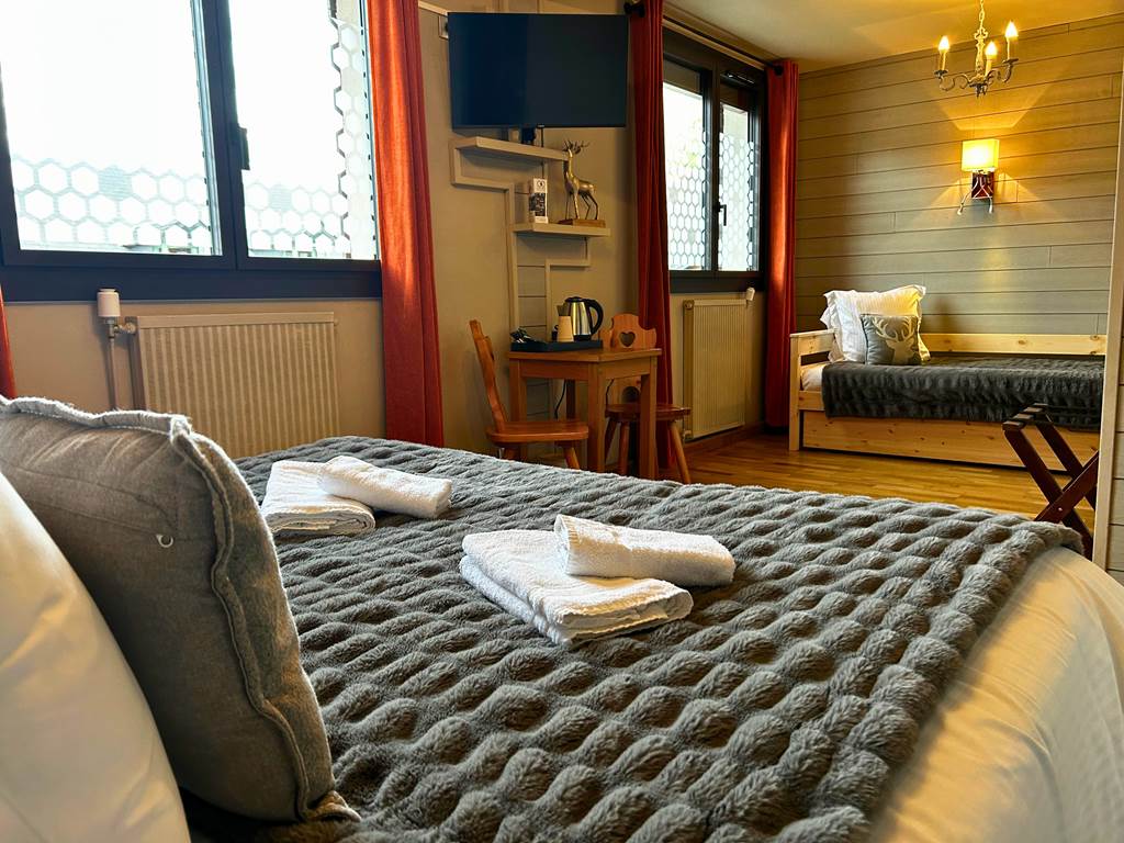 Chambre triple authentique (Chambre 11) avec décoration boisée et ambiance chaleureuse à l'Hôtel La Rencluse, Bagnères-de-Luchon.
