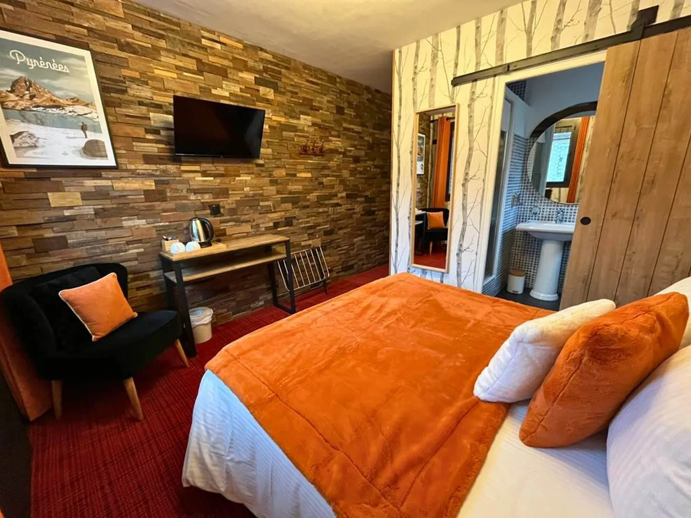 Salle de bain privative de la chambre n°3 avec porte coulissante en bois, lavabo colonne et douche géothermale aux vertus apaisantes.