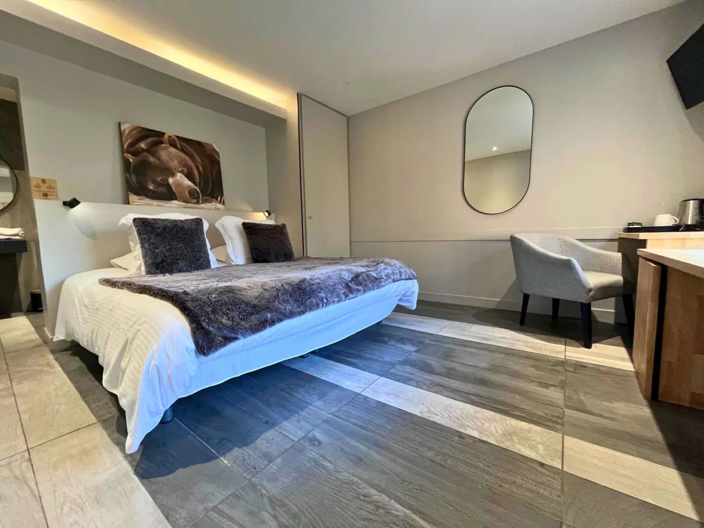 Chambre double PMR n°25 avec grand lit King-size, luminaire en bois massif et tableau d'ours polaire.