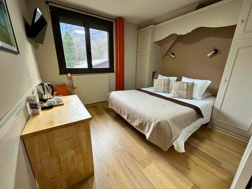 Vue globale de la chambre double cosy n°9 avec grand lit queen-size, décoration épurée et plafond mansardé.