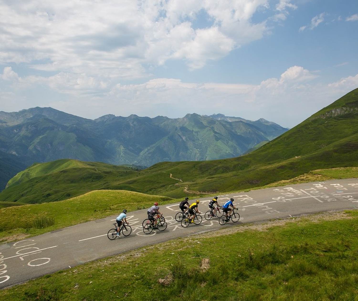 Groupe de cyclistes en pleine ascension d'un col mythique du Tour de France (Peyresourde ou Portillon) dans les montagnes de Luchon.