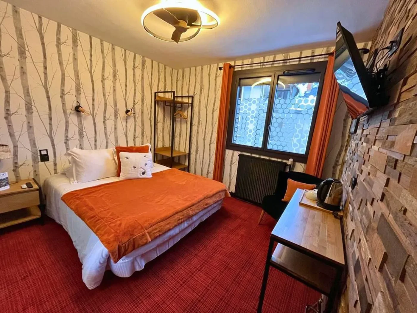 Perspective de la chambre n°3 montrant la fenêtre donnant sur Luchon, le téléviseur écran plat et le mobilier en bois massif.