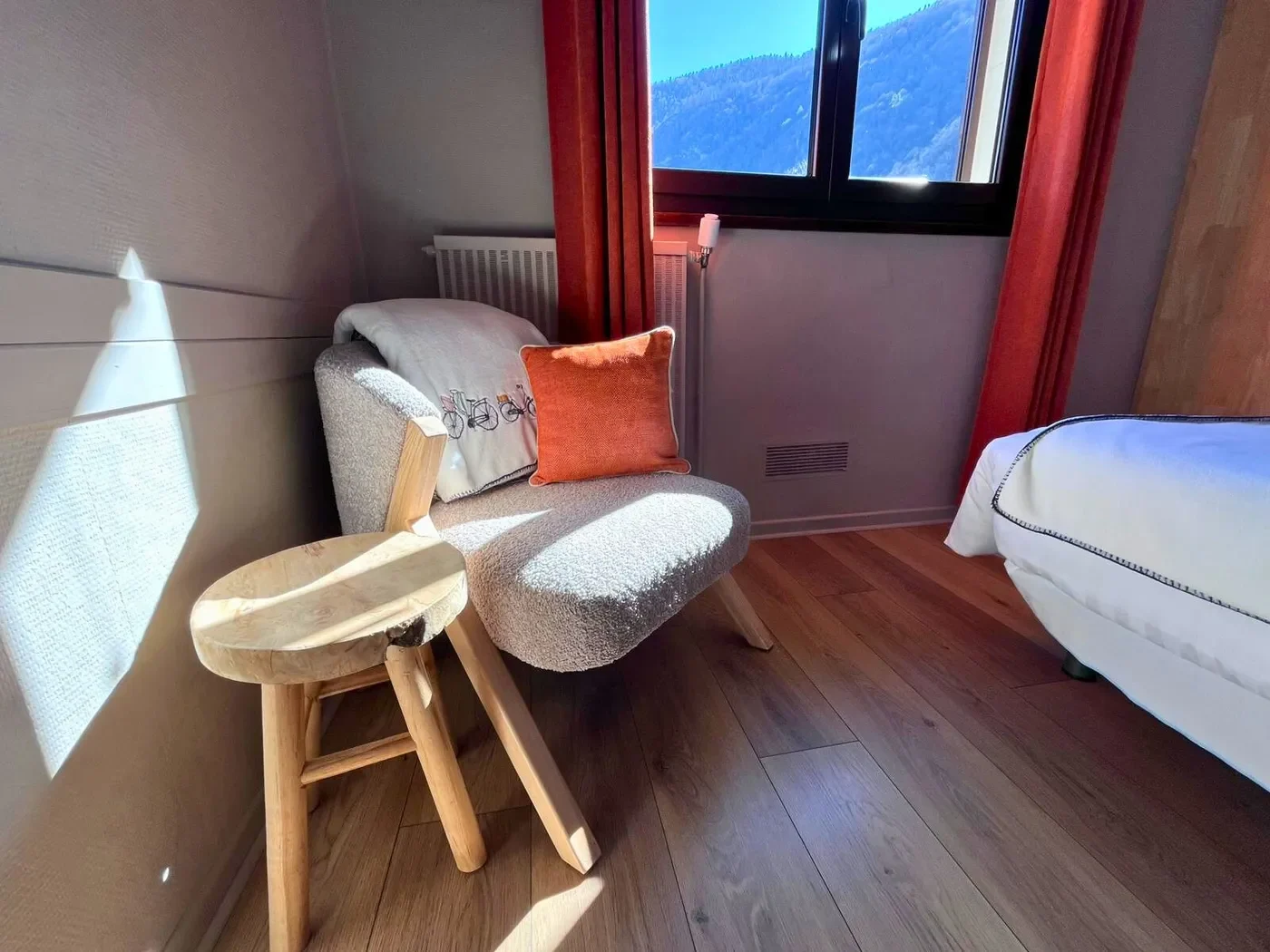 Détail des décorations murales dans la chambre n°8 avec tableaux d'inspiration montagne et luminaires en bois clair.