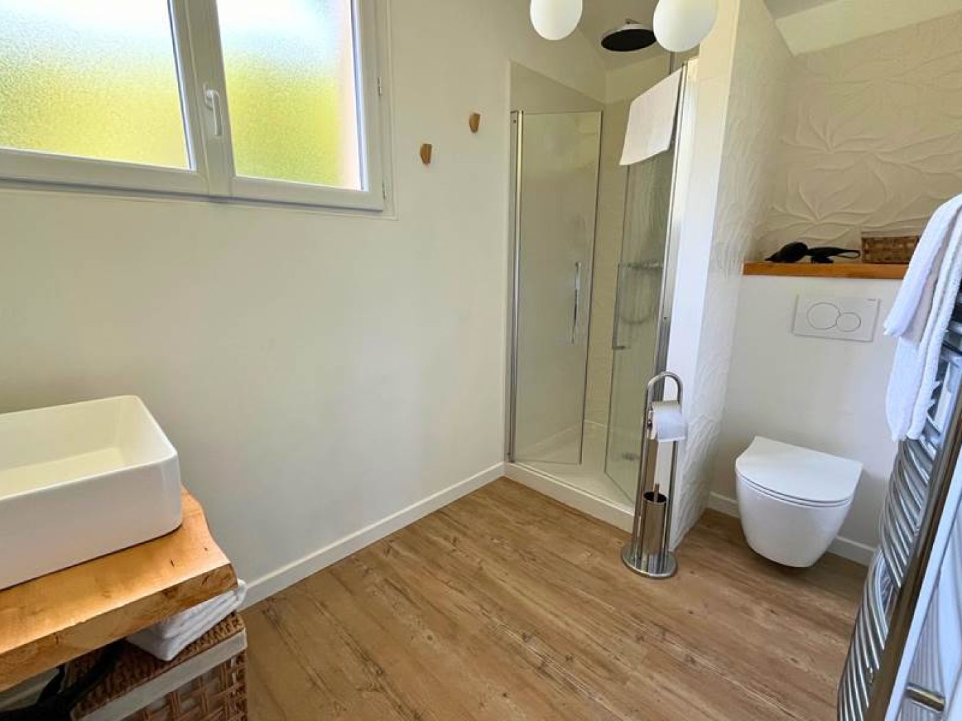 Détail de la douche de l'appartement T2 avec pommeau géothermal et mosaïques bleues.