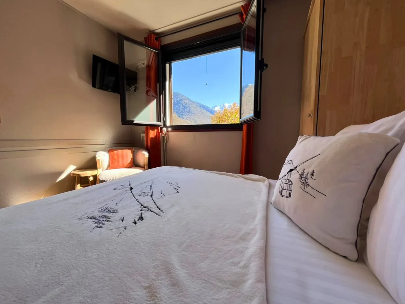 Vue imprenable sur les sommets enneigés des Pyrénées depuis une fenêtre ouverte de la chambre double de l'Hôtel La Rencluse.