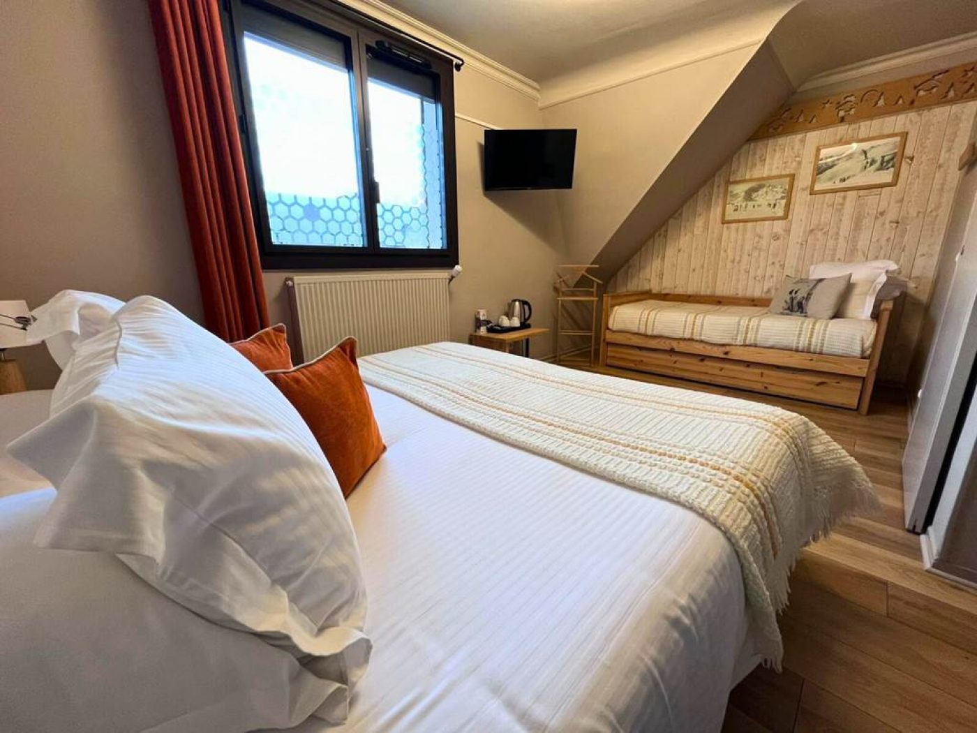 Perspective large de la chambre triple 14 montrant le lit double au premier plan et le lit simple au fond, sous les toits.