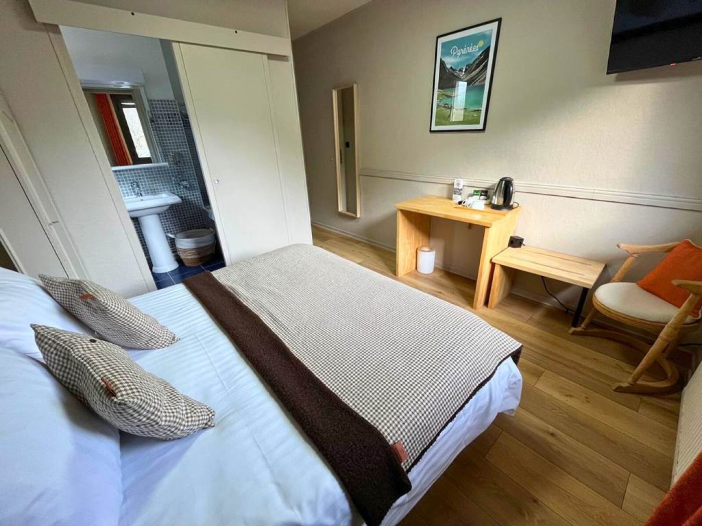 Perspective de la chambre n°9 montrant le lit double et l'accès direct à la salle de bain privative mansardée.