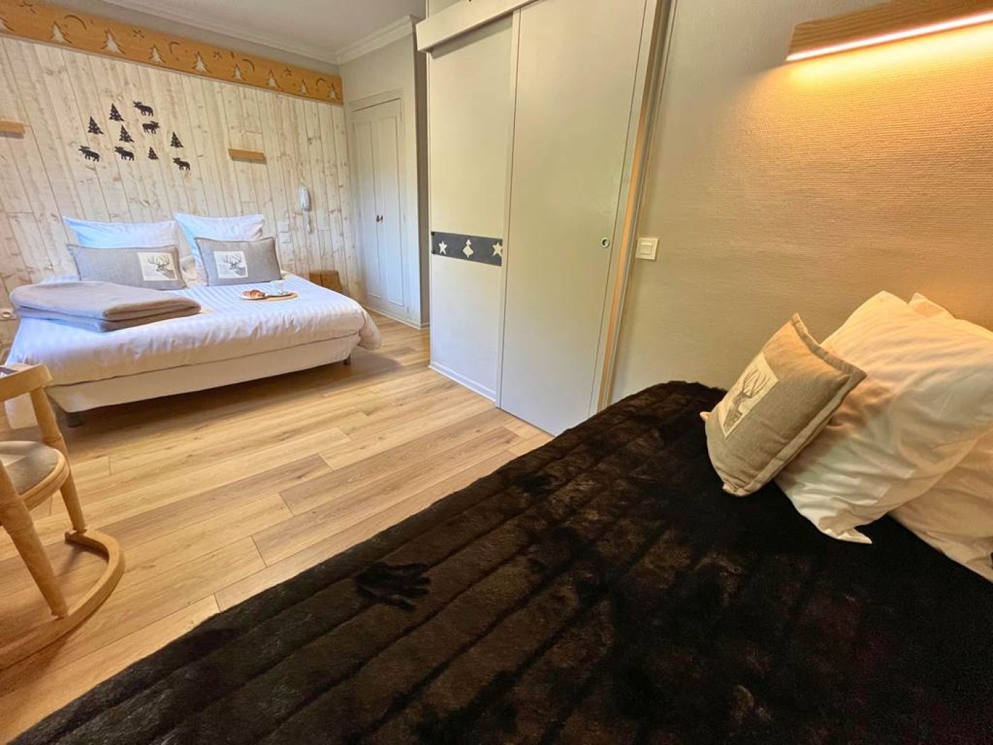 Perspective depuis le pied du lit simple montrant l'espace vers le lit double et la porte coulissante.