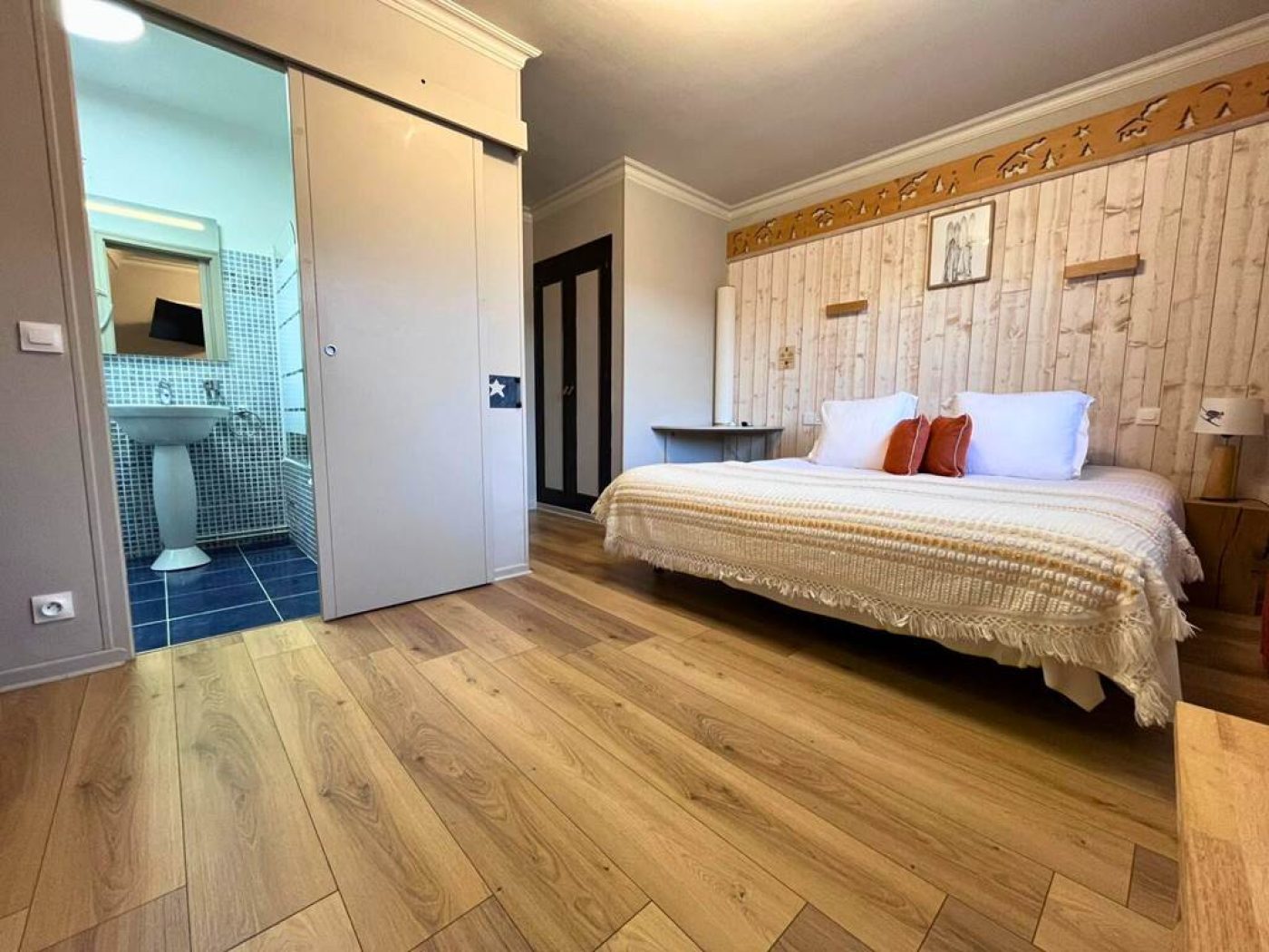 Vue du lit simple et de l'entrée de la salle de bain équipée d'une douche géothermale en chambre 14.