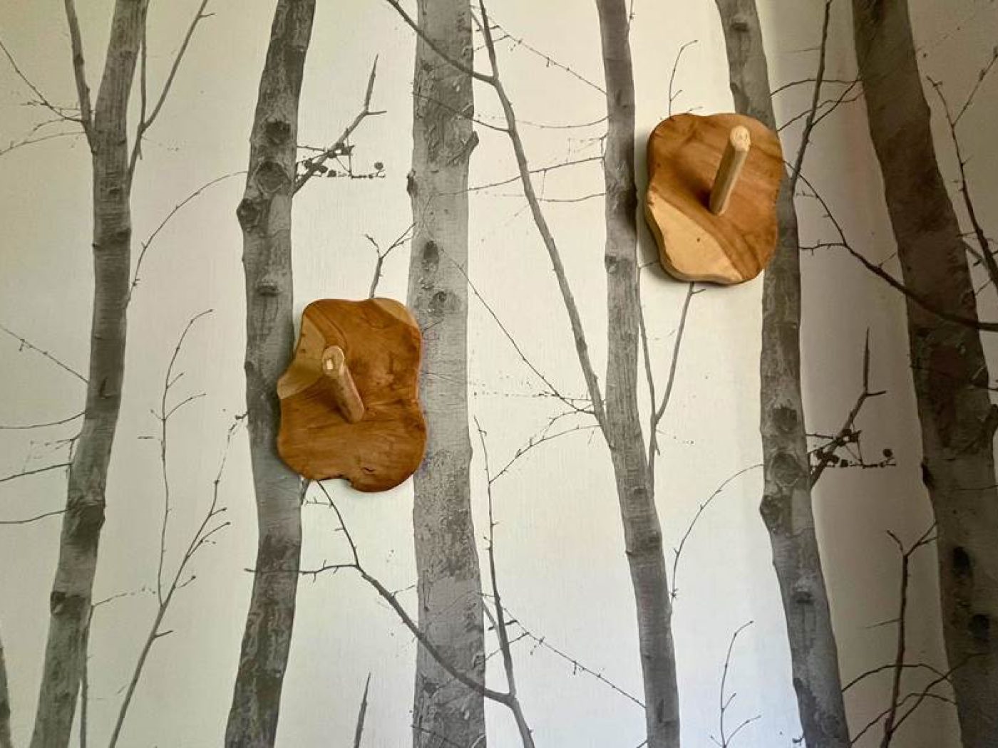 Porte-manteau design en bois massif et miroir dans l'entrée de l'appartement T2.