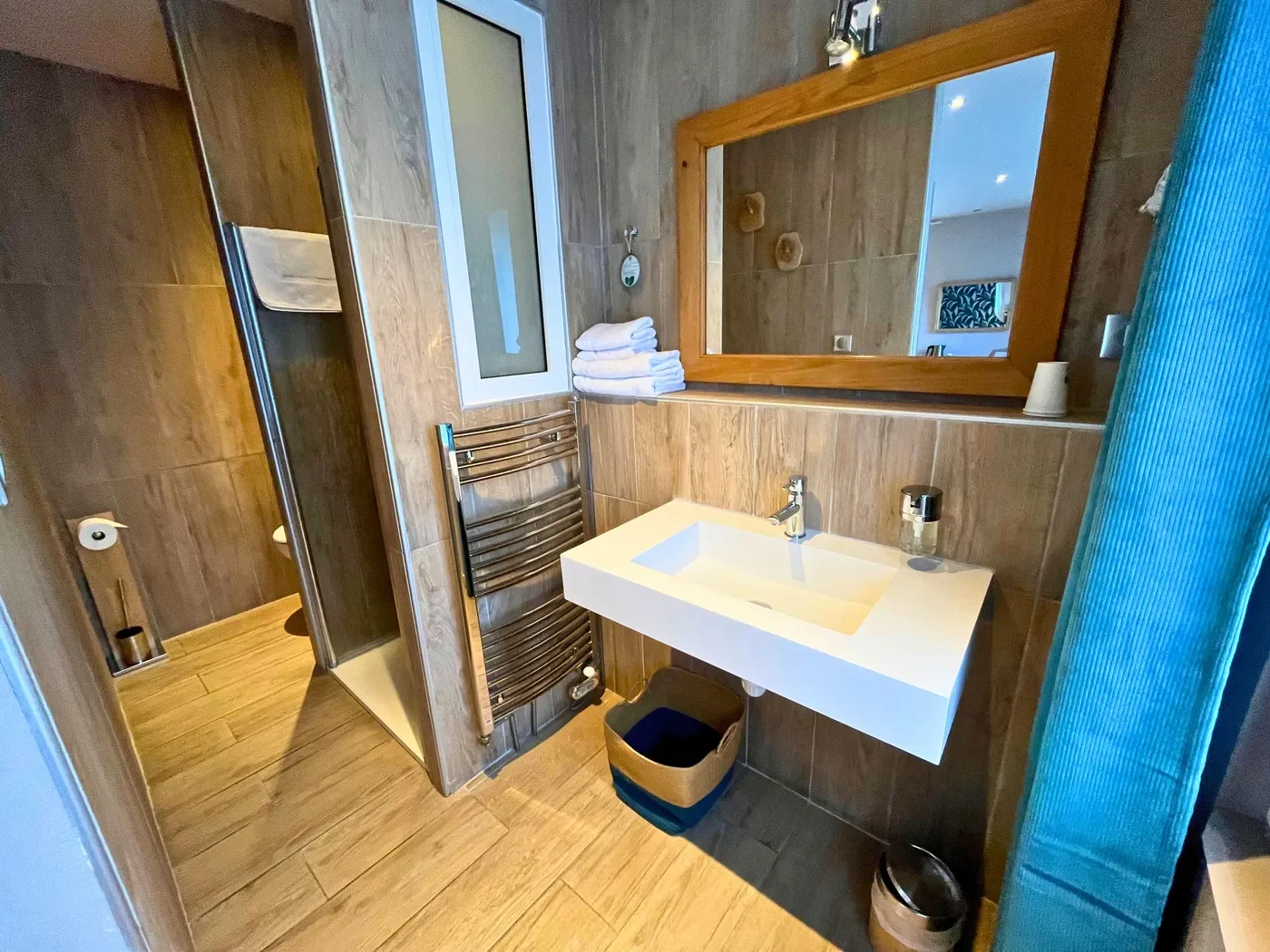 Salle de bain contemporaine de la chambre 32 avec douche à l'italienne, vasque design et carrelage effet bois.