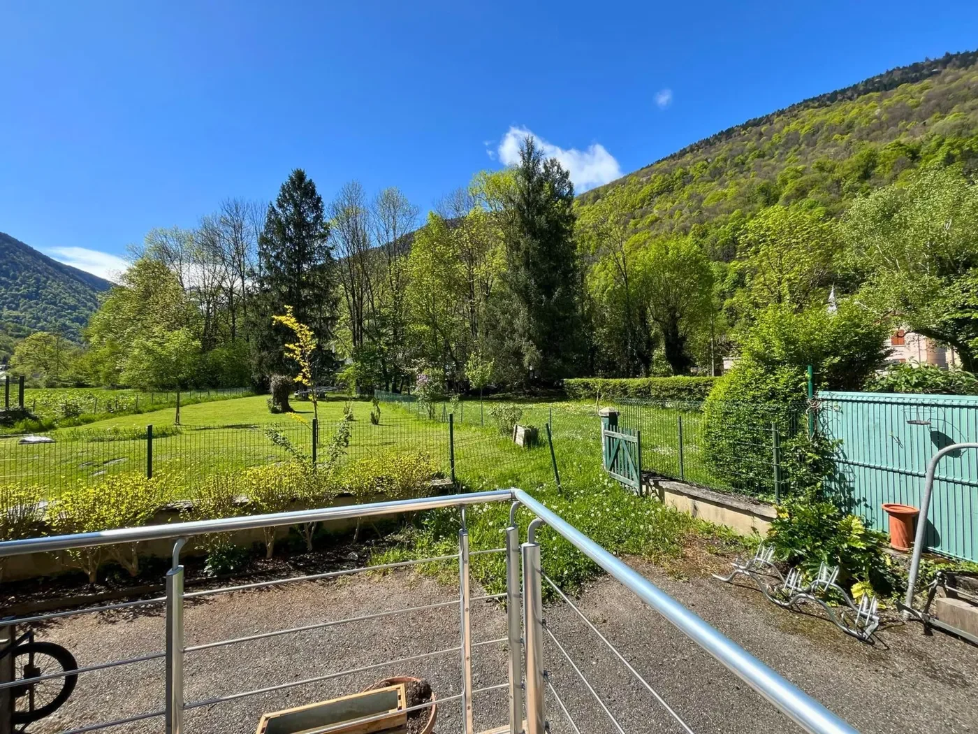 Panorama sur les montagnes verdoyantes et le grand jardin depuis la terrasse de la chambre 32.